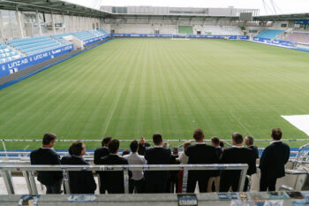 Menschen in Business Kleidung stehen auf der Stadiontribühne